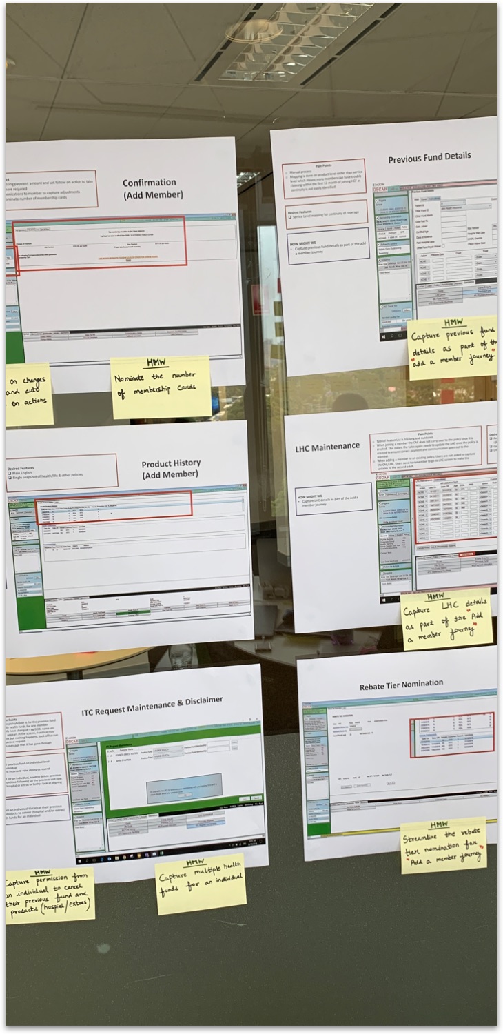 Current-state screens and How Might We notes pinned up at the workshop.
